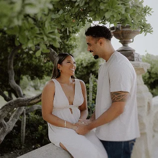 Couple holding hands during a romantic photoshoot in a Barcelona garden