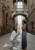 Surprise proposal under Pont del Bisbe in Barcelona, partner kneeling with ring box