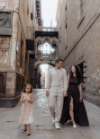 Family walking together through Pont del Bisbe archway in Barcelona’s Gothic Quarter