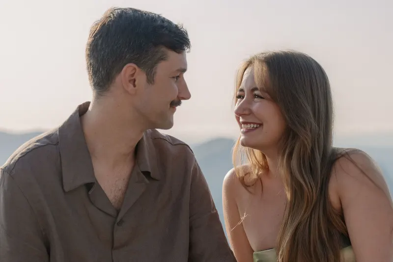 A close portrait of Tim and Megan smiling at each other.