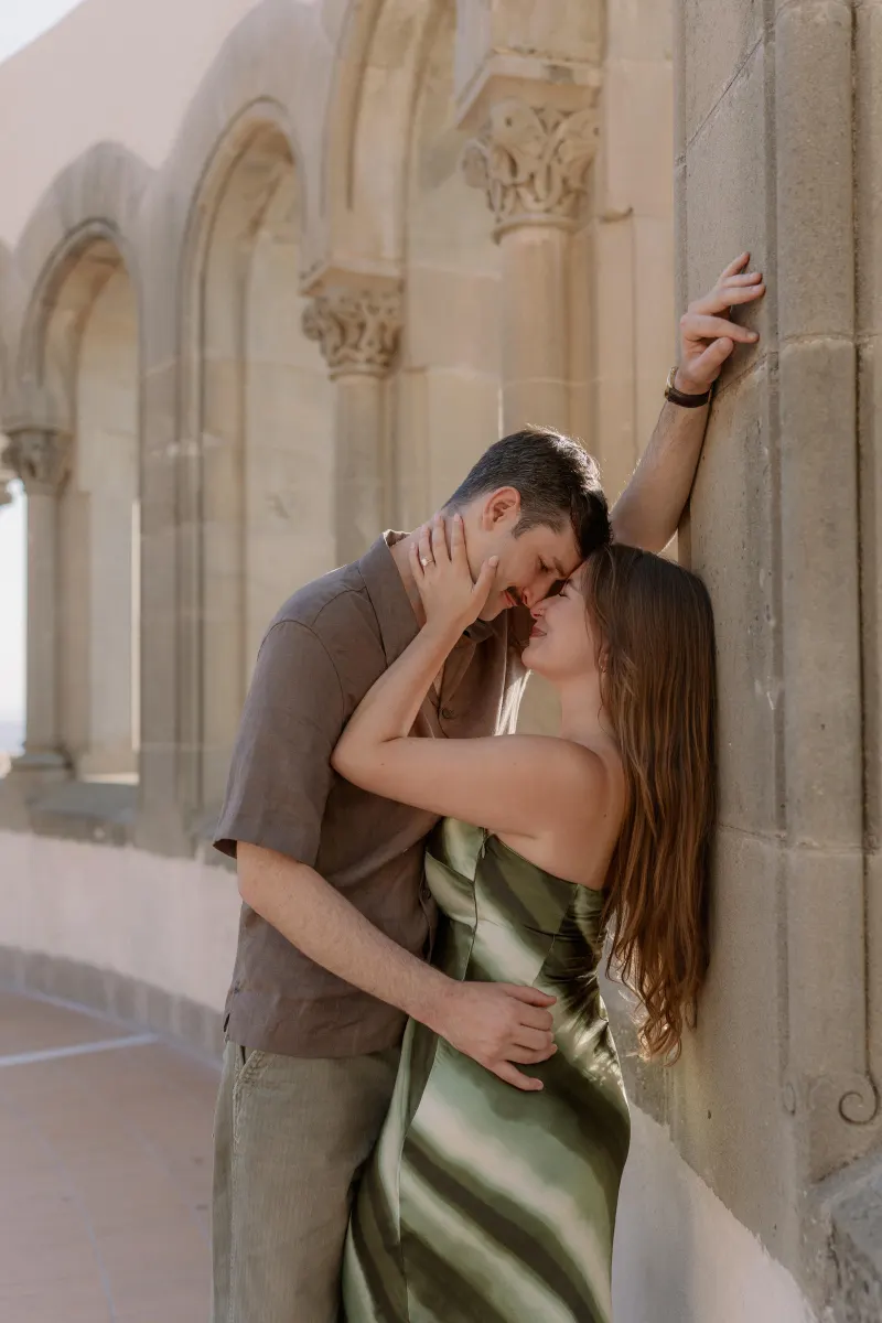 A close view of Tim and Megan kissing among the stone arches.