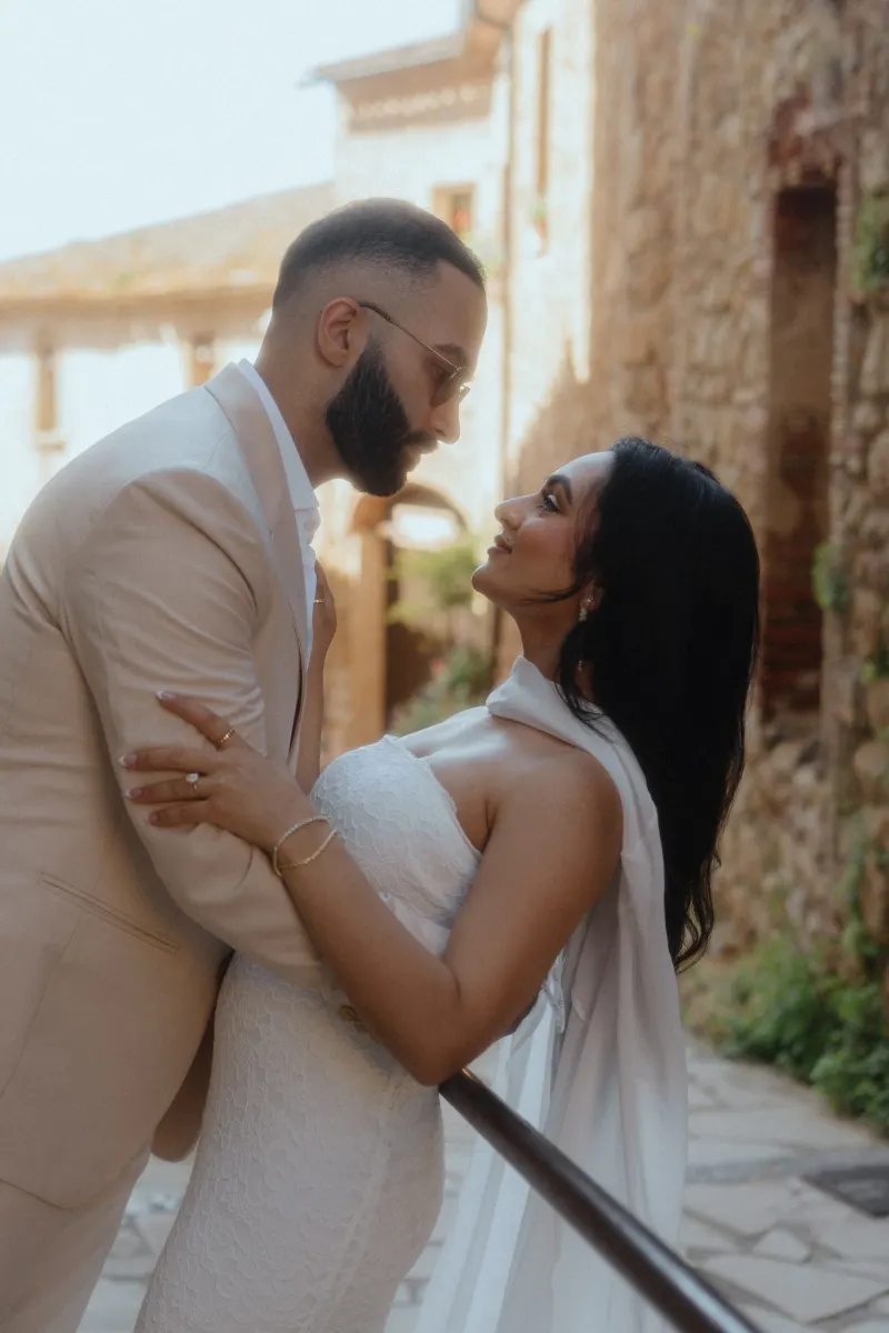A couple embraces and gazes into each other's eyes on a rustic stone path during their surprise proposal photoshoot.