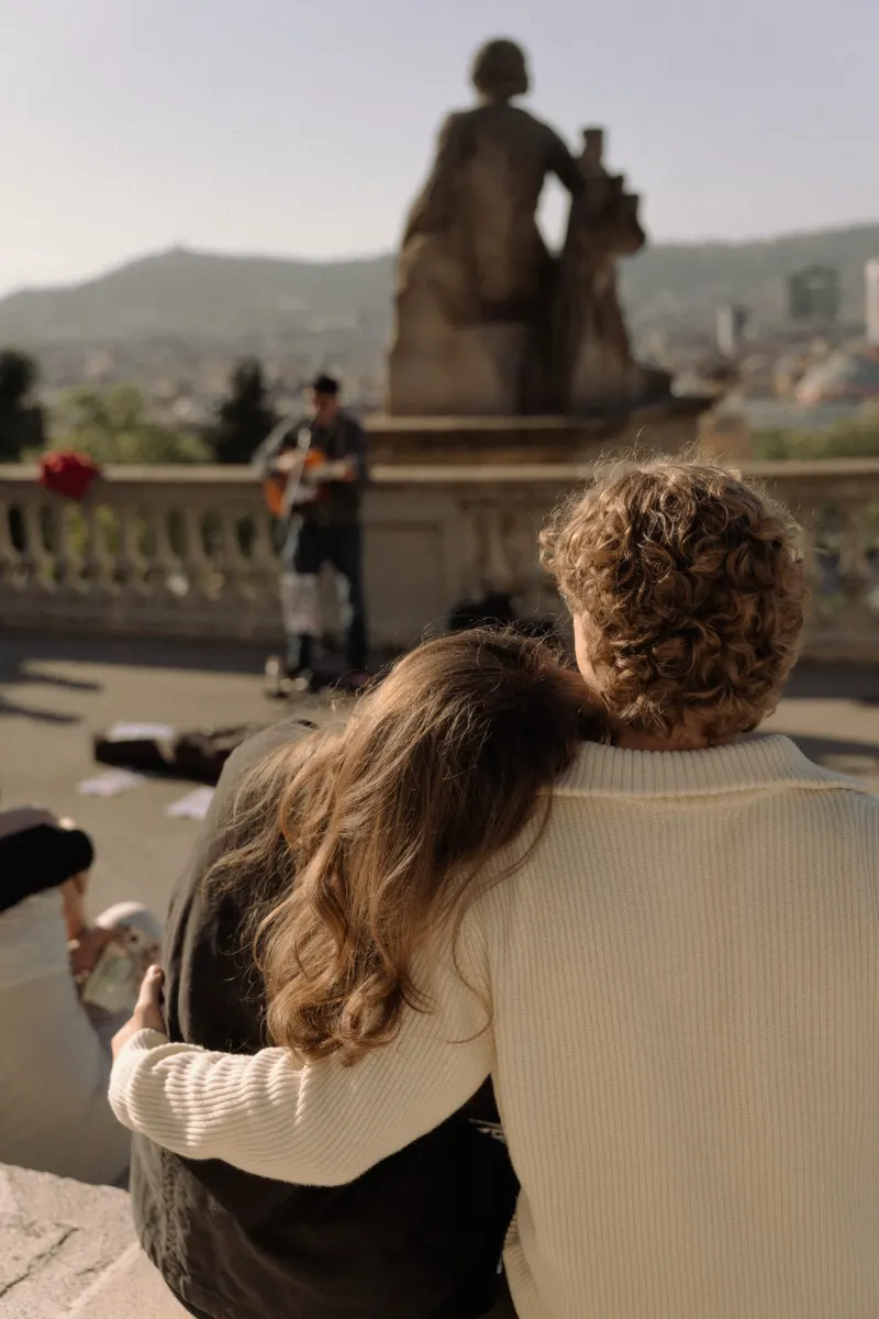 A couple embraces on a sunlit terrace in Barcelona, captured during a relaxed couples & engagements photoshoot.