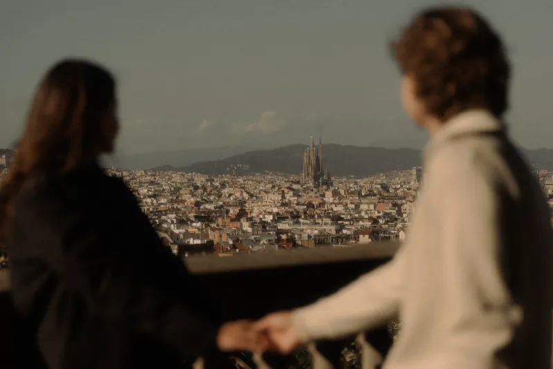 A couple holds hands while admiring Barcelona’s skyline, captured during a romantic couples & engagements photoshoot.