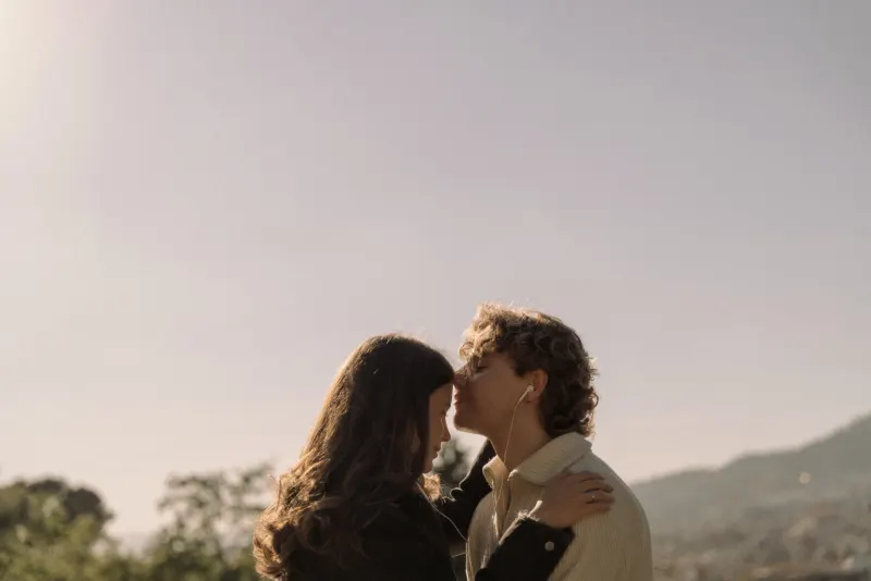 A couple shares a gentle forehead kiss at golden hour in Barcelona, captured during a couples & engagements photoshoot.