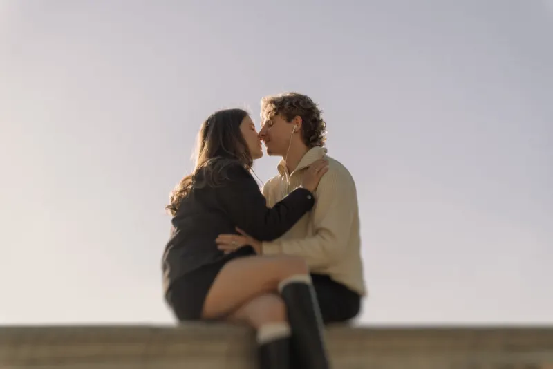 A couple shares a gentle kiss while listening to music together during a couples & engagements photoshoot in Barcelona.