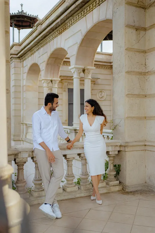 A couple shares a happy, relaxed moment on a sunlit terrace during their surprise proposal photoshoot in Barcelona.