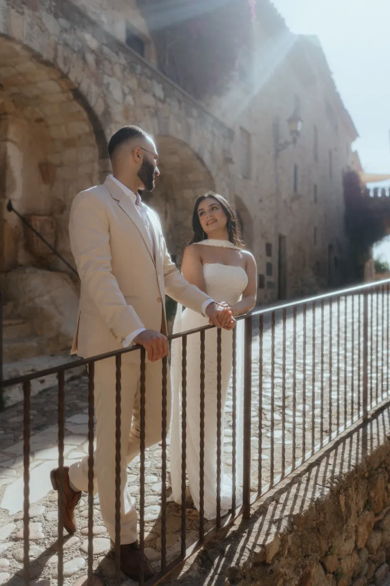 A couple shares a loving gaze on a sunlit stone path, captured during their surprise proposal photoshoot.