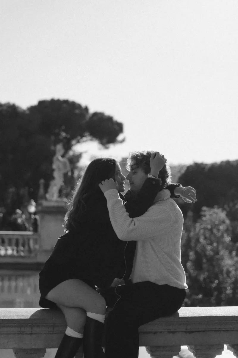 A couple shares a loving gaze on a sunlit terrace in Barcelona during a couples & engagements photoshoot.