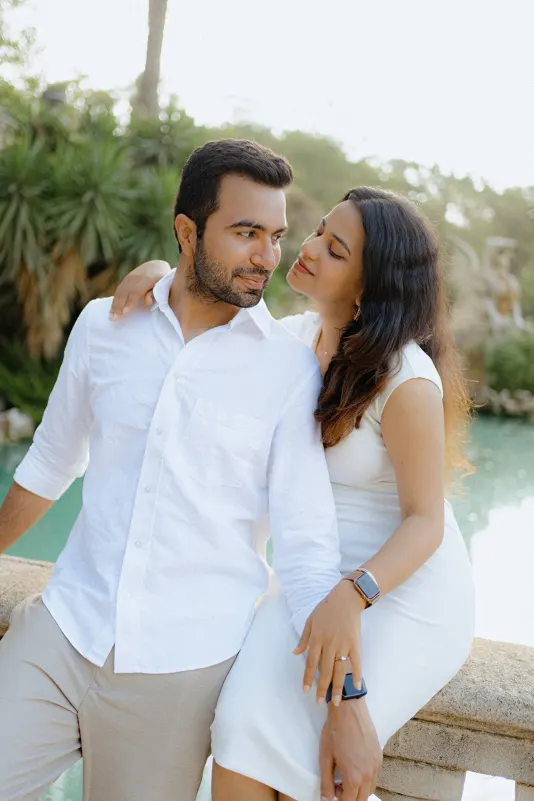 A couple shares a loving moment by the water at Parc de la Ciutadella during their surprise proposal photoshoot.