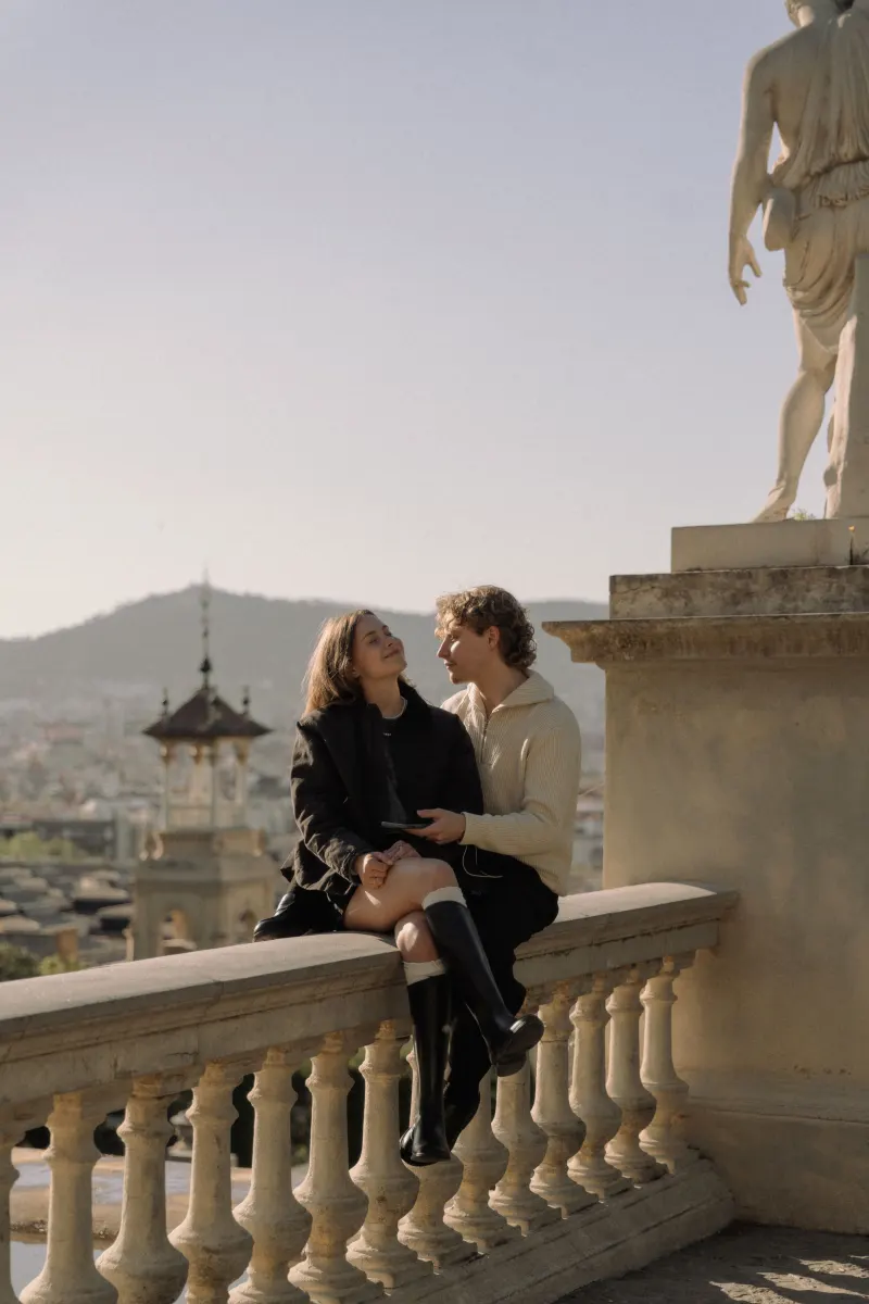 A couple shares a loving smile on a stone balcony in Barcelona, captured during a couples & engagements photoshoot.