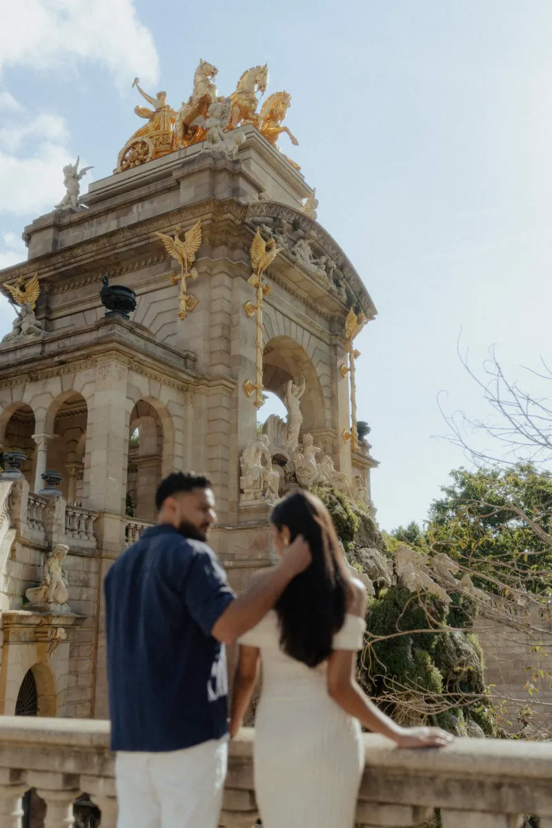 A couple shares a quiet, affectionate moment on a stone terrace during an engagement photoshoot at a historic monument.
