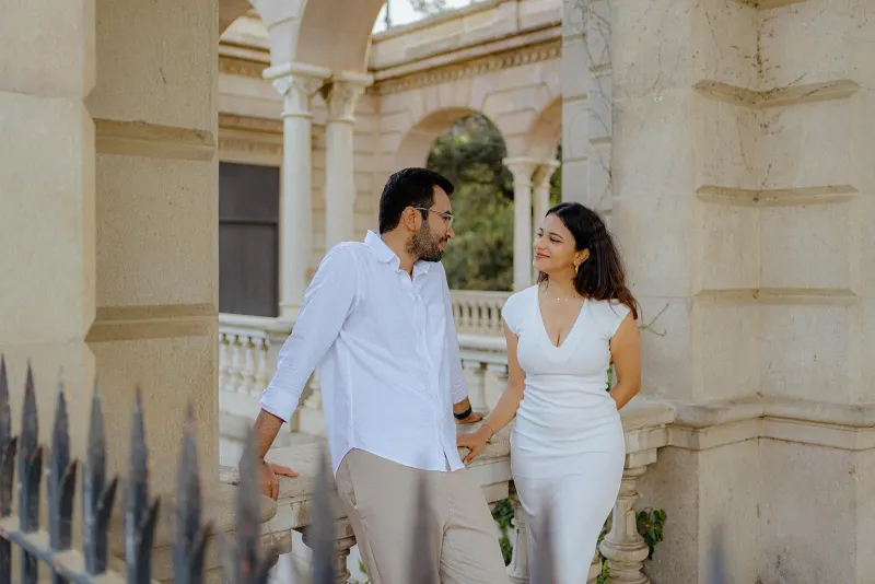 A couple shares a quiet, affectionate moment on a sunlit terrace during their surprise proposal photoshoot in Barcelona.