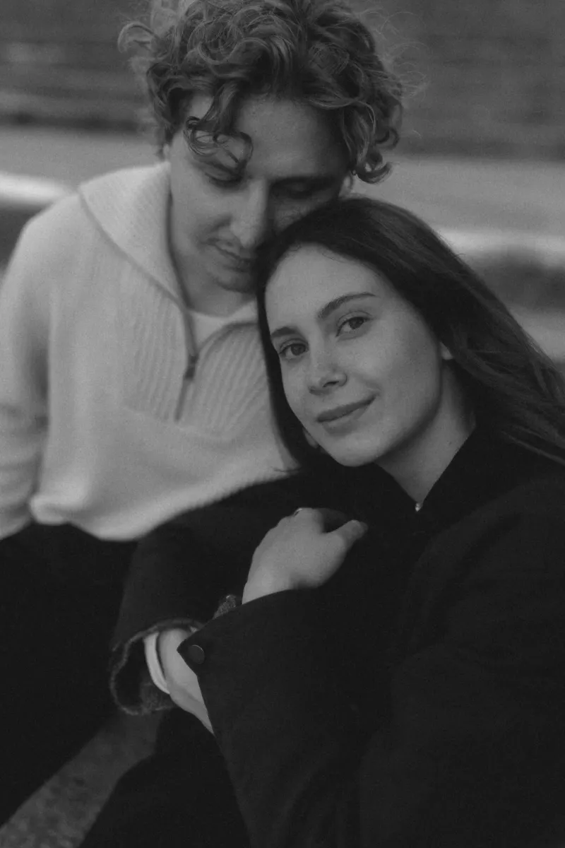 A couple shares a quiet, intimate moment during their engagement photoshoot in Barcelona, captured in soft black and white.