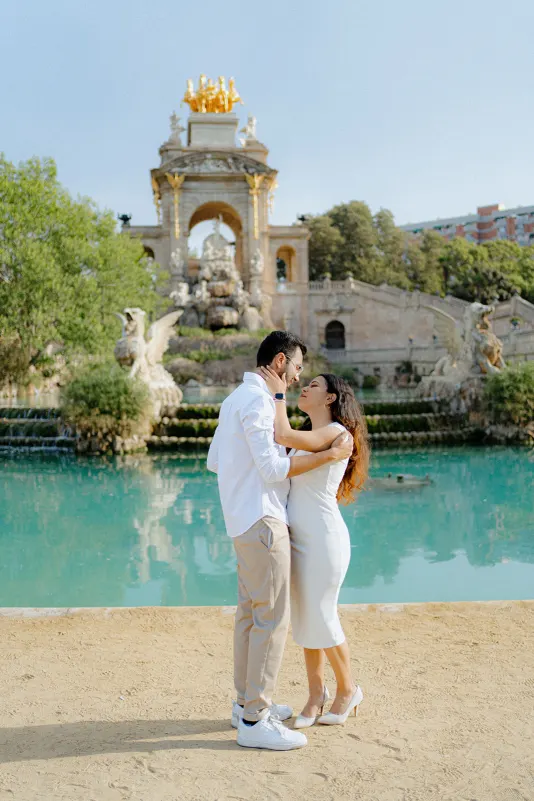 A couple shares a romantic embrace by the fountain at Parc de la Ciutadella during a surprise proposal photoshoot.