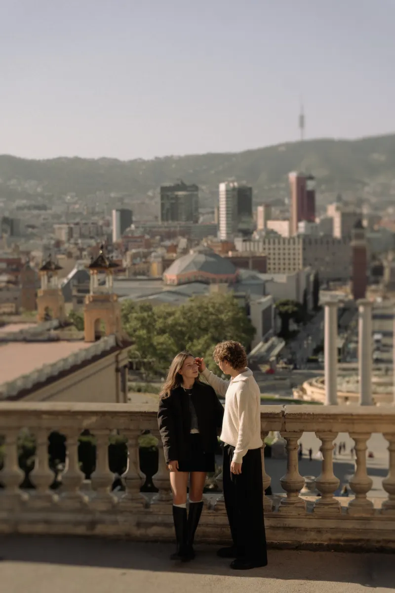 A couple shares a tender moment on a terrace in Barcelona during an engagement photoshoot.
