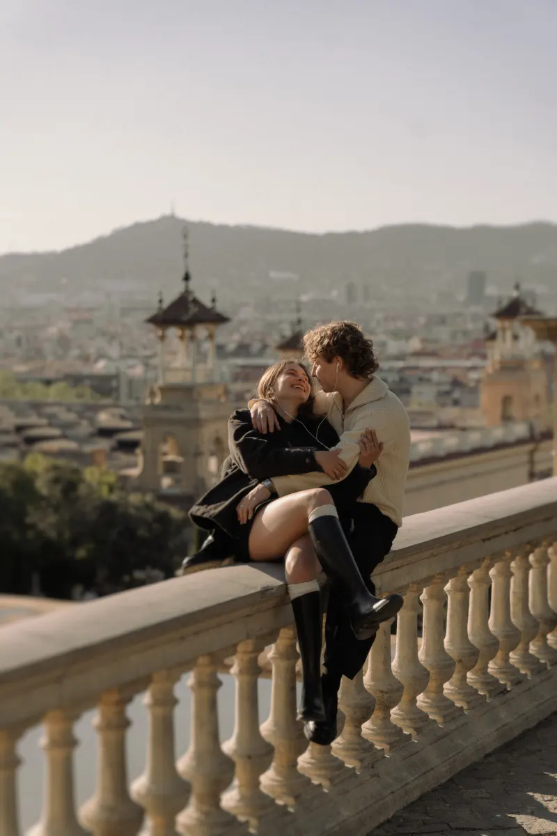 A couple shares laughter and music on a terrace above Barcelona, captured during a couples & engagements photoshoot.