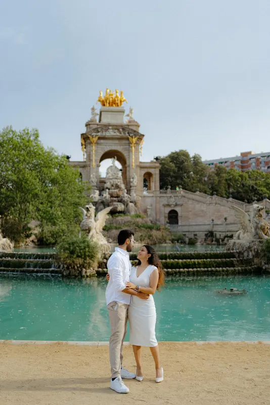 A couple smiles at each other by the fountain at Parc de la Ciutadella during a surprise proposal photoshoot.