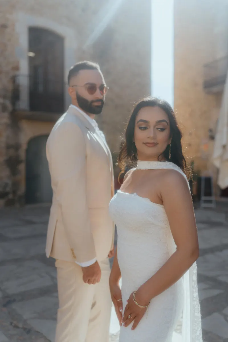 A couple stands in soft sunlight, sharing a quiet, emotional moment during their surprise proposal photoshoot.