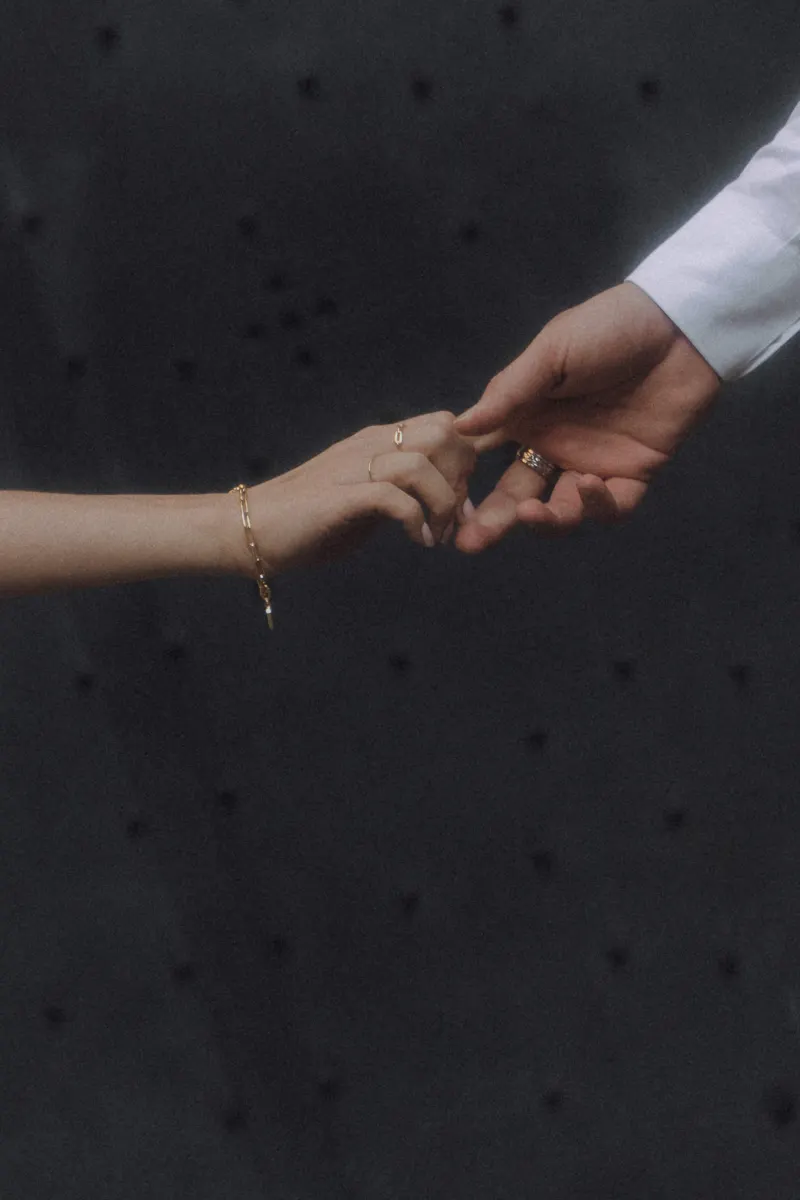A couple’s hands gently reaching for each other, highlighting connection during a couples & engagements photoshoot.