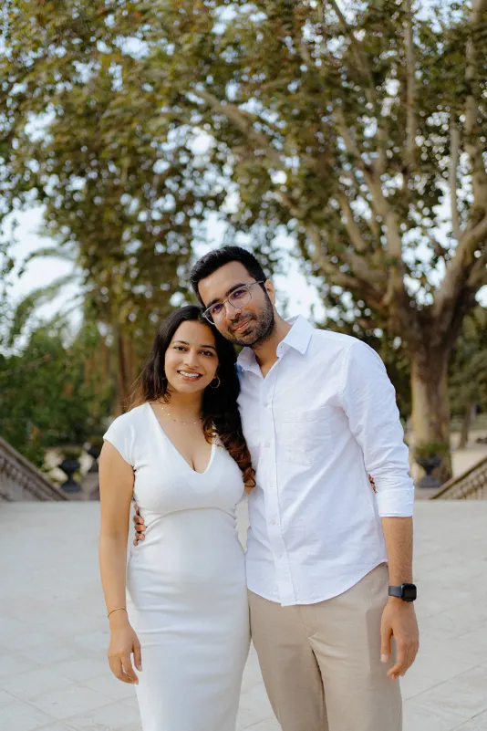 A happy couple poses arm in arm, smiling warmly during their surprise proposal photoshoot at Parc de la Ciutadella.