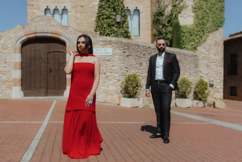 A stylish couple poses in front of Begur’s stone architecture during their surprise proposal photoshoot.