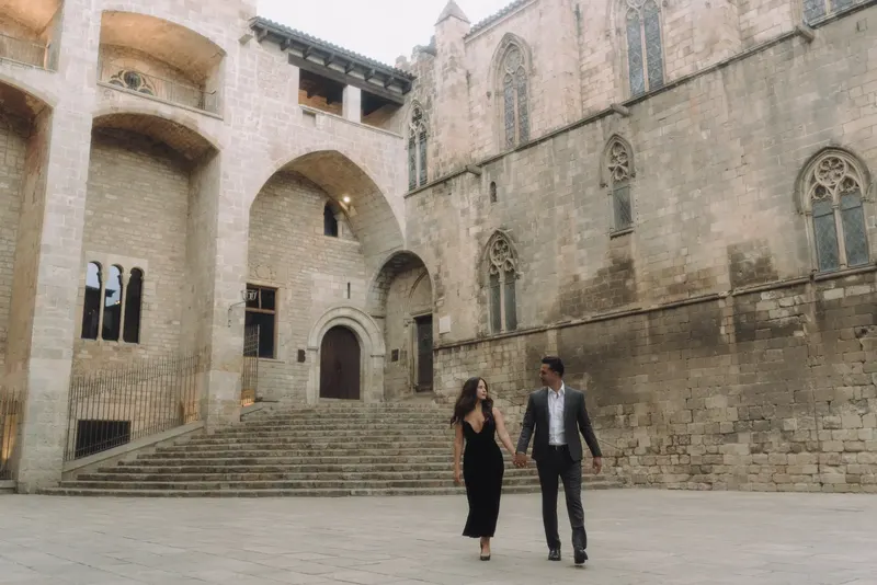 A wide portrait of Ashley and Edgar standing together in Plaça del Rei.