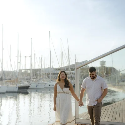 Ariel and Gabriel walking hand in hand by the marina in Barcelona