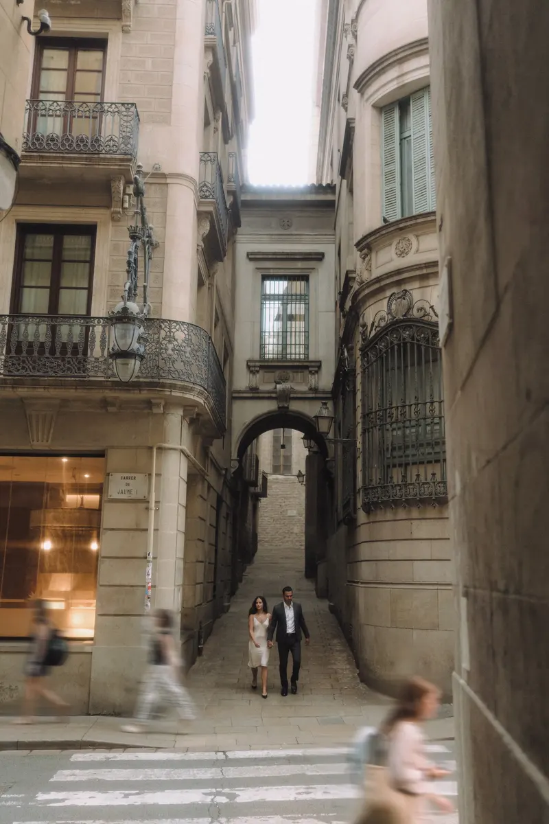 Ashley and Edgar cross a narrow Gothic Quarter lane as Barcelona begins to wake.