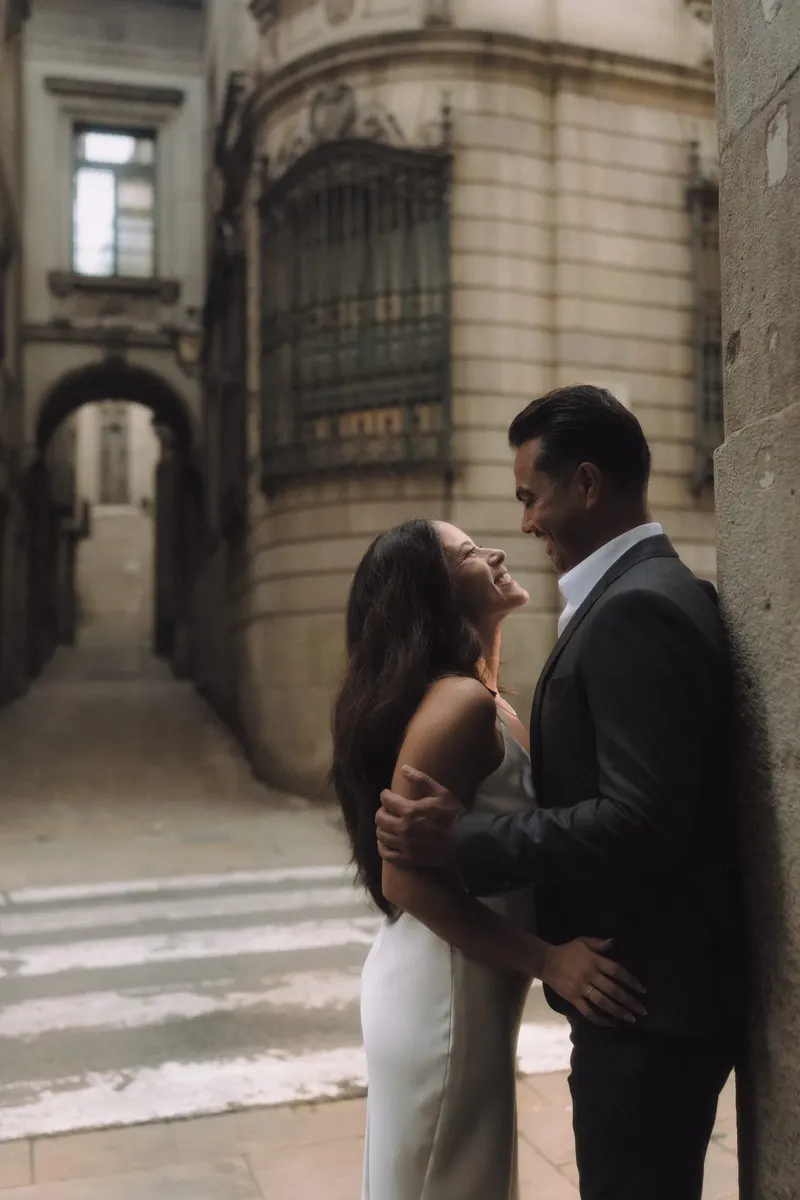 Ashley and Edgar laugh together on a quiet Barcelona street after changing outfits.