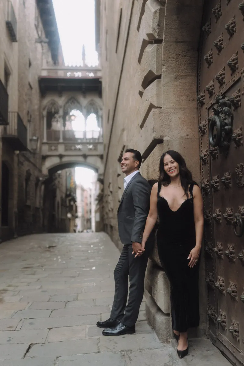 Ashley and Edgar lean against an ornate doorway during their elegant Barcelona couple photoshoot.