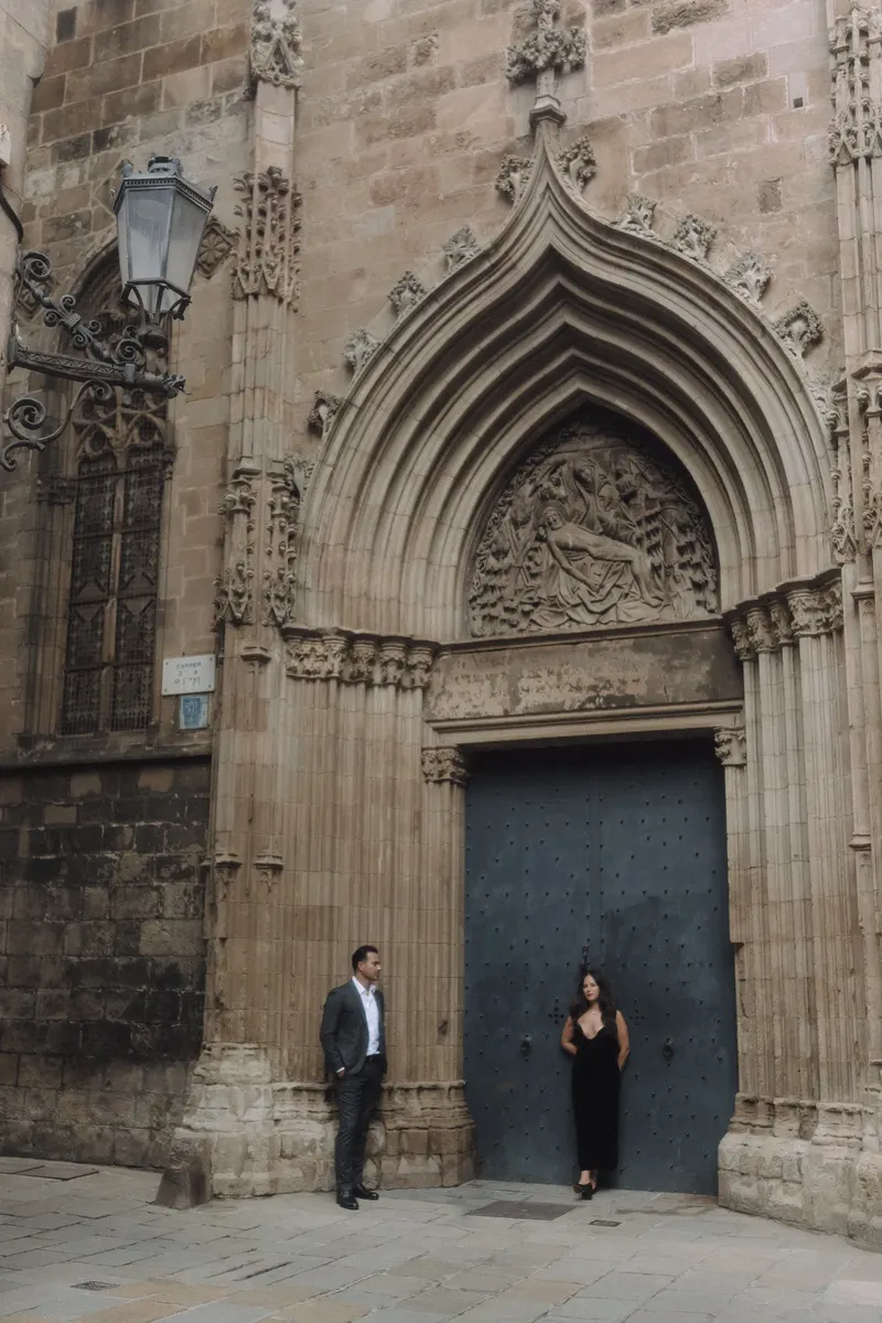 Ashley and Edgar pose beside an ornate blue church door in the old city of Barcelona.