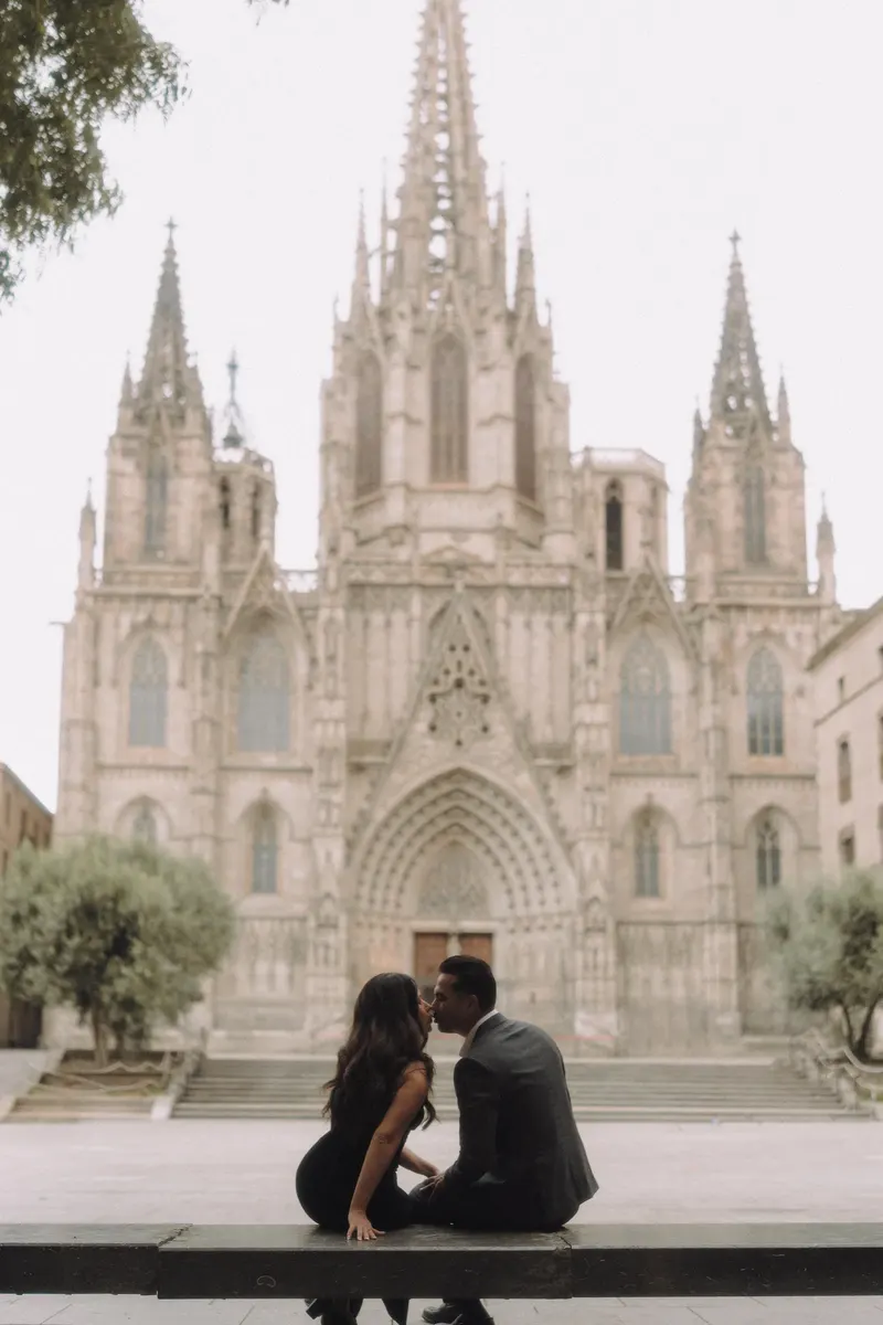 Ashley and Edgar sit together on the cathedral steps during an early morning couple photoshoot in Barcelona.