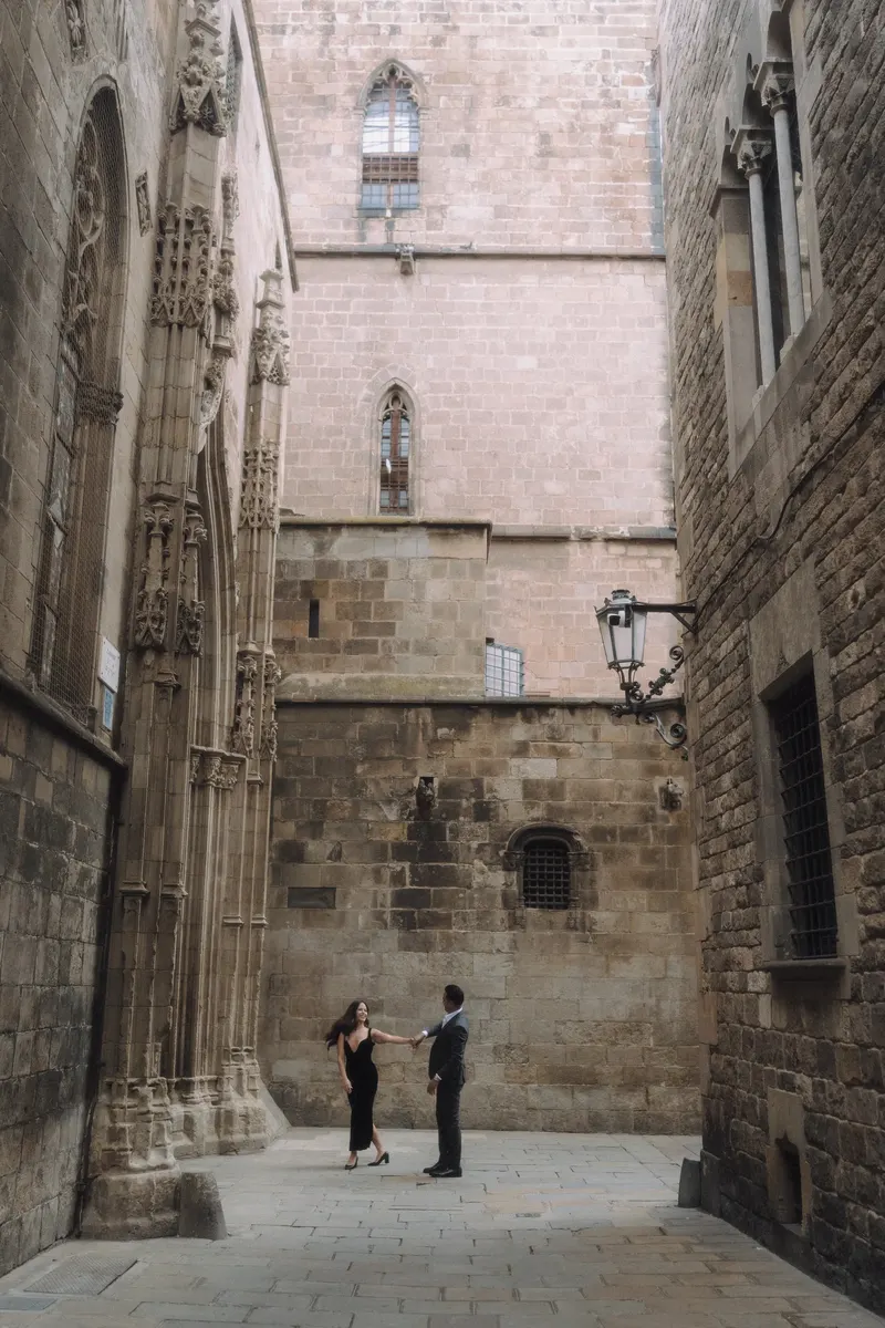 Ashley and Edgar stand at the end of a narrow stone lane in Barcelona's Gothic Quarter.