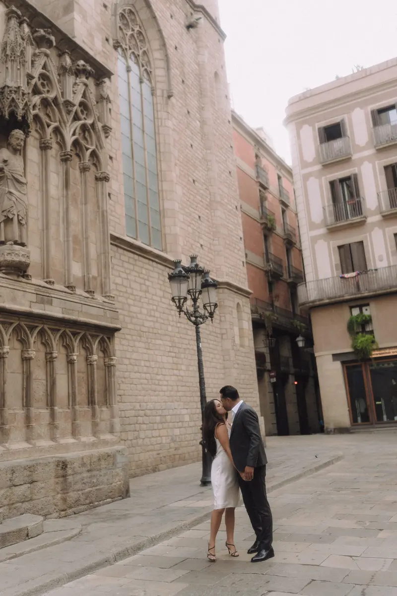 Ashley and Edgar stand together beside a historic church in Barcelona's Gothic Quarter.
