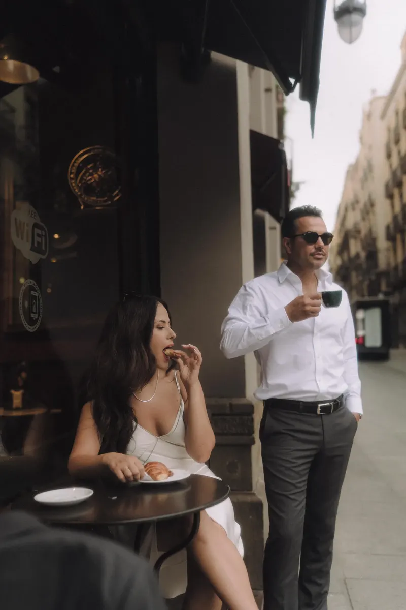 Ashley laughs while Edgar drinks coffee outside a cafe in the Gothic Quarter.