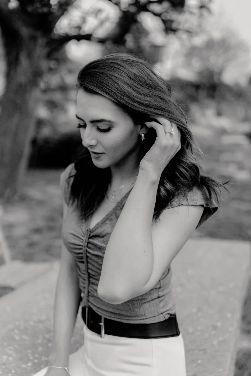 Bride-to-be admires her engagement ring, lost in a quiet moment after a countryside surprise proposal photoshoot.