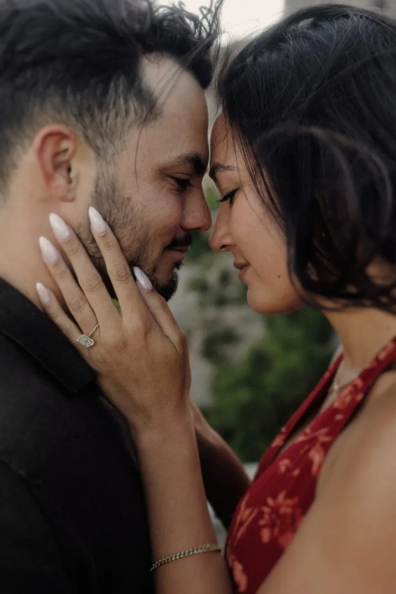 Close portrait of Dan and Sydney touching foreheads as her engagement ring catches the light.