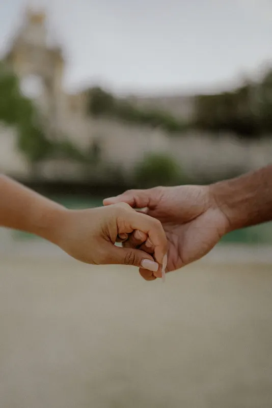 Close-up of a couple gently holding hands during an engagement photoshoot at Parc de la Ciutadella.