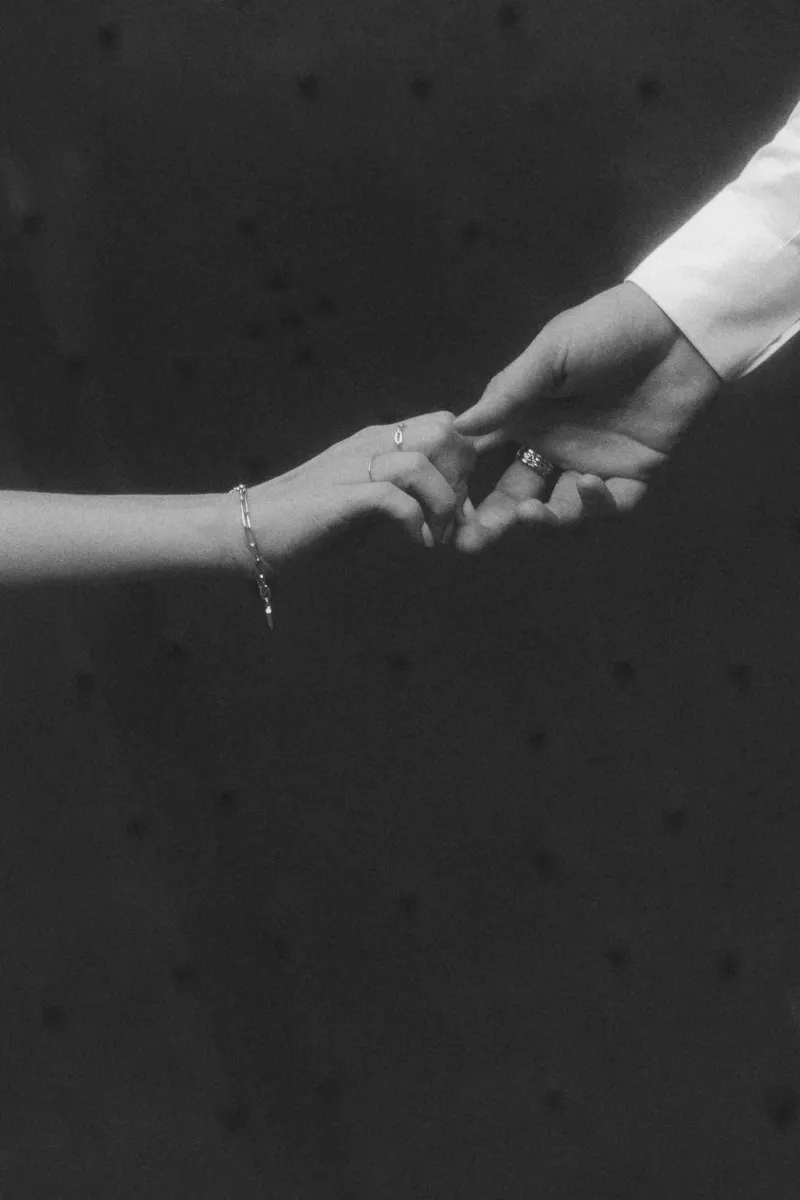 Close-up of a couple gently holding hands, engagement ring visible, captured during a couples & engagements photoshoot.