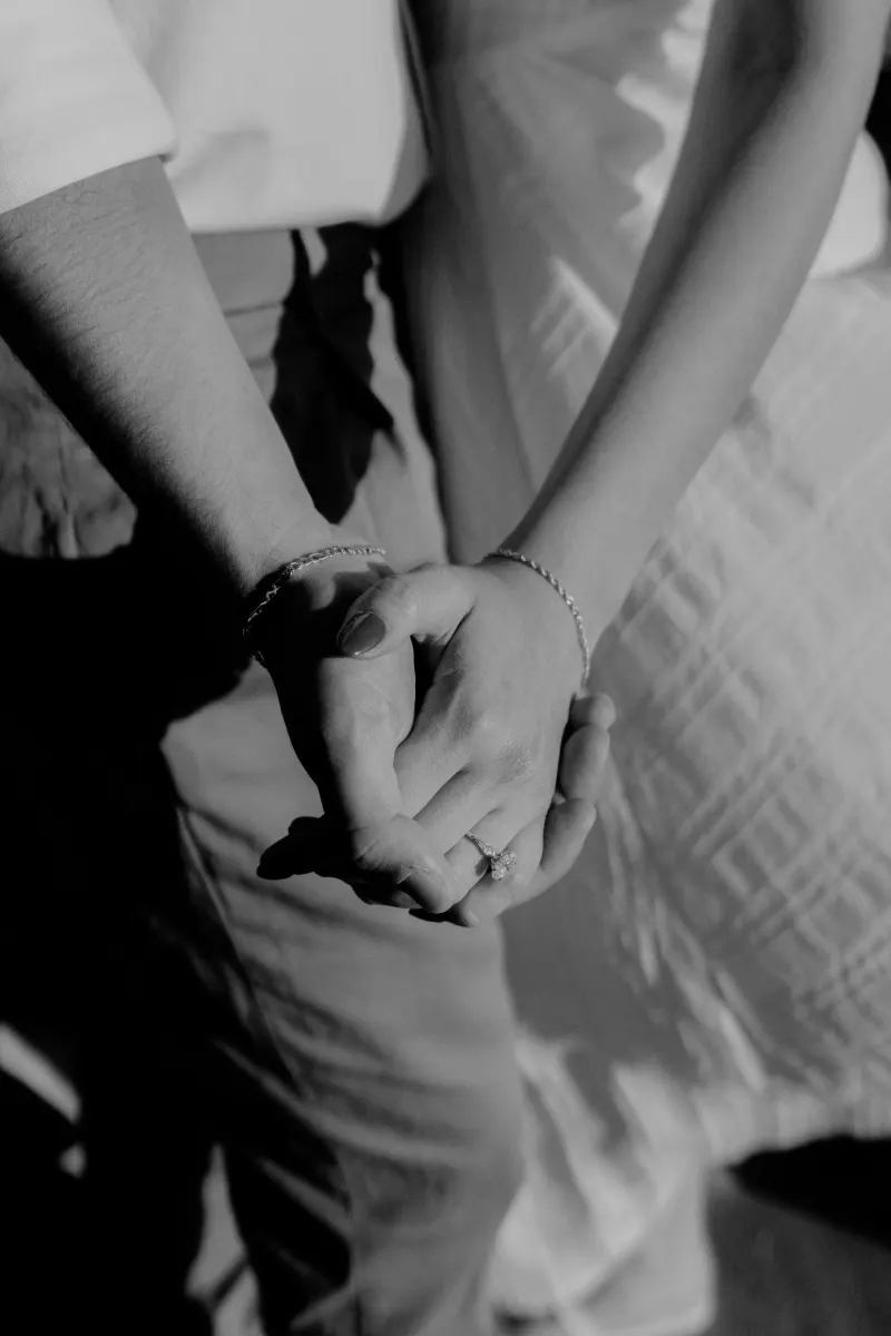 Close-up of a couple holding hands, her engagement ring sparkling, captured during a couples & engagements photoshoot.