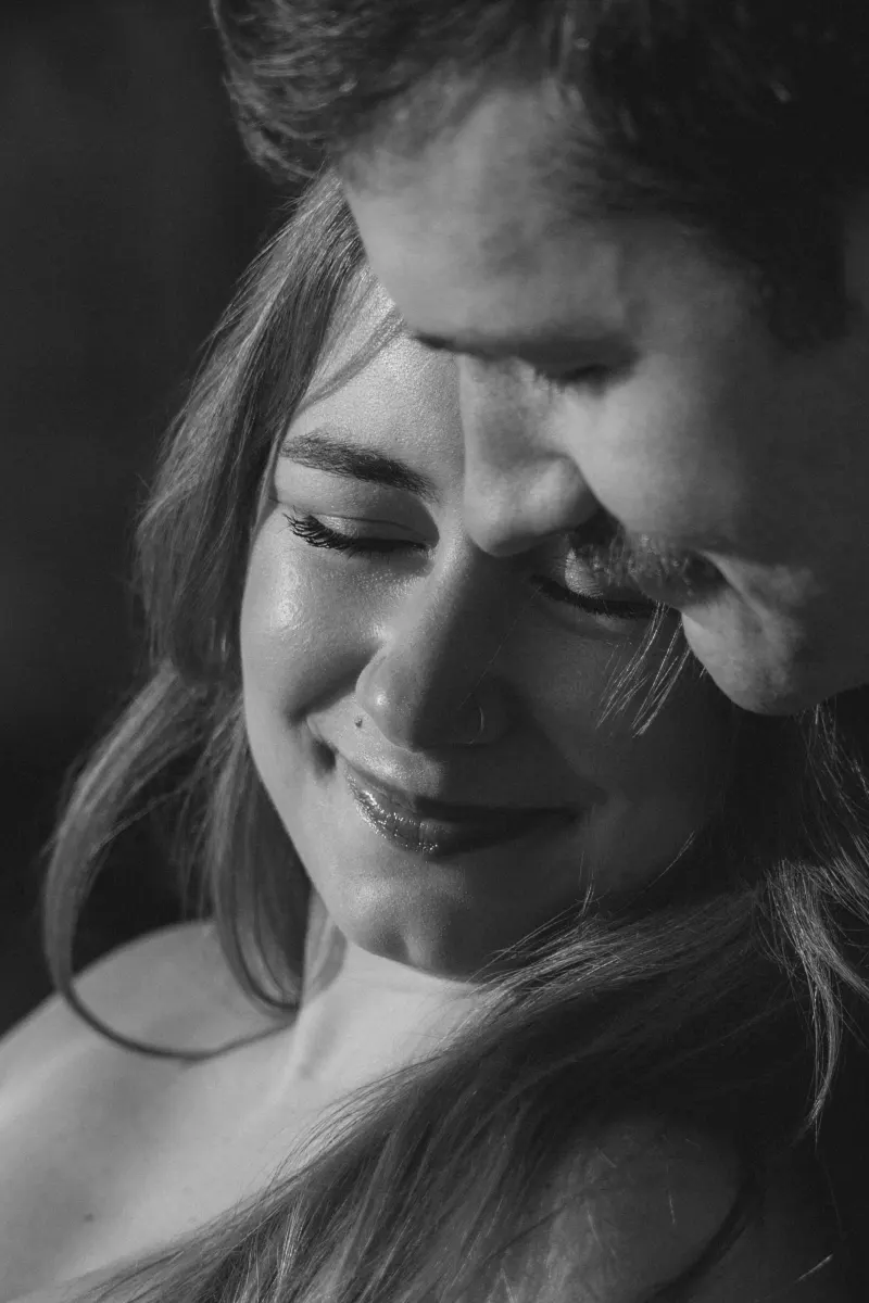 Close-up of a couple sharing a tender moment, capturing the joy of a surprise proposal photoshoot.