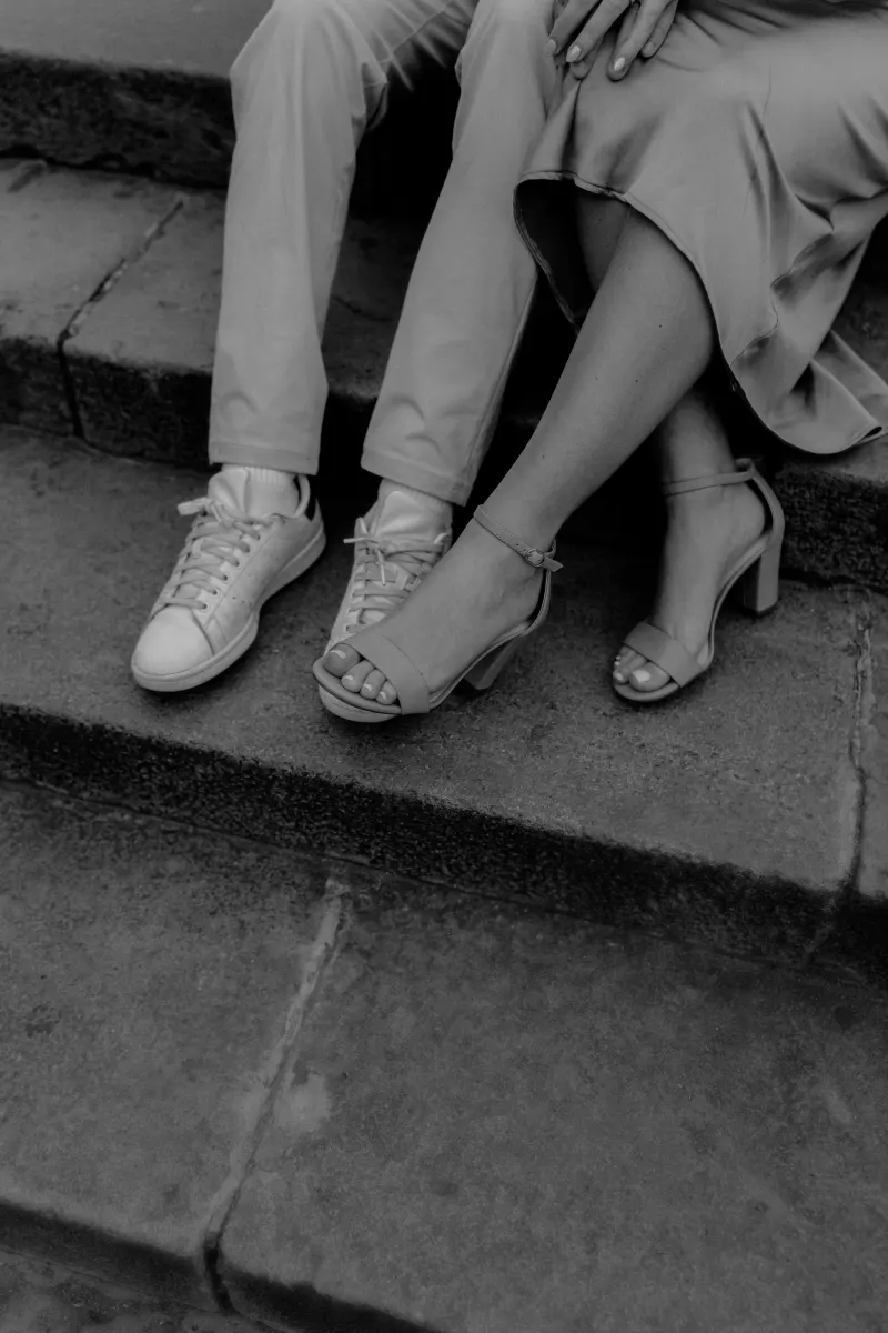 Close-up of a couple’s legs and feet touching on stone steps, captured during a Vacation Portraits photoshoot in Barcelona.