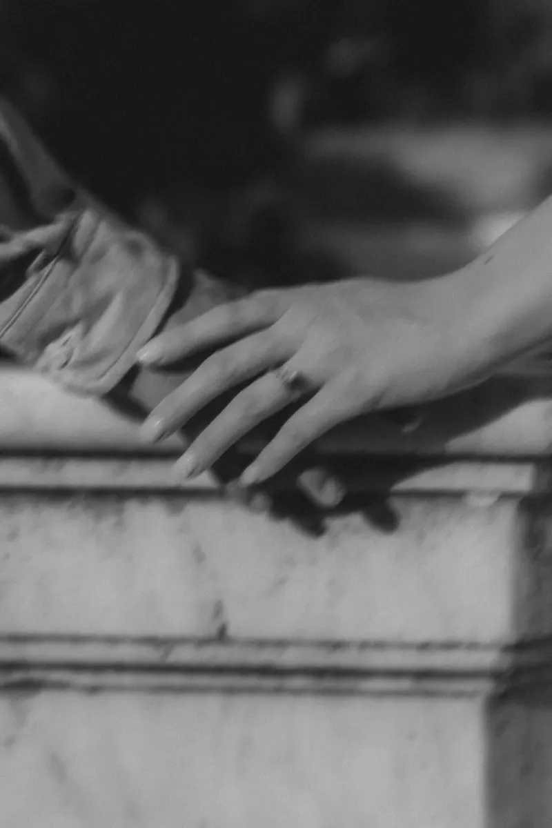 Close-up of a hand with an engagement ring gently resting on a partner’s arm during a Mediterranean proposal session.