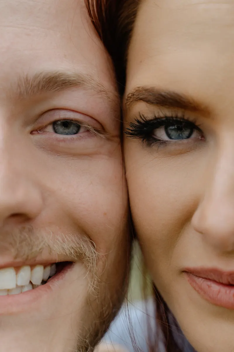 Close-up of a smiling couple, faces touching, capturing excitement and connection during a surprise proposal photoshoot.