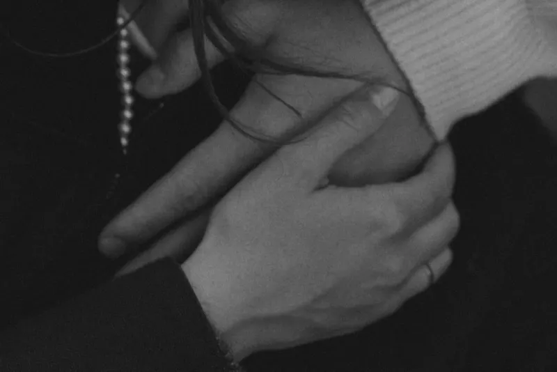 Close-up of intertwined hands, capturing a quiet, intimate moment during a couples & engagements photoshoot in Barcelona.