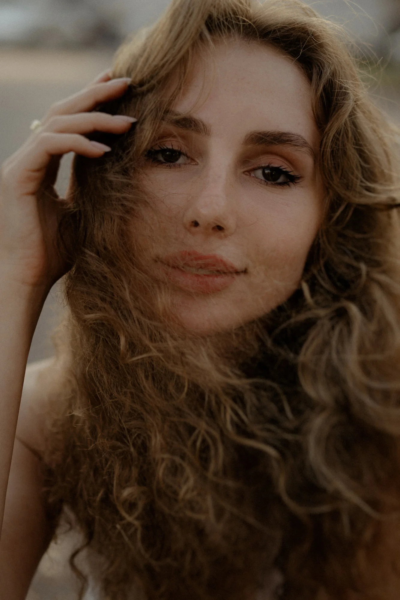 Close-up portrait of a woman with wavy hair and a gentle smile, captured during a Vacation Portraits photoshoot.