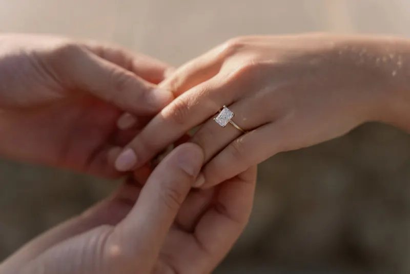 Close view of Megan's engagement ring with Tim holding her hand.