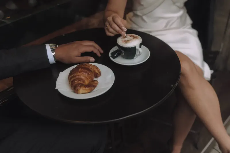 Coffee and a croissant on the cafe table during Ashley and Edgar's morning in Barcelona.