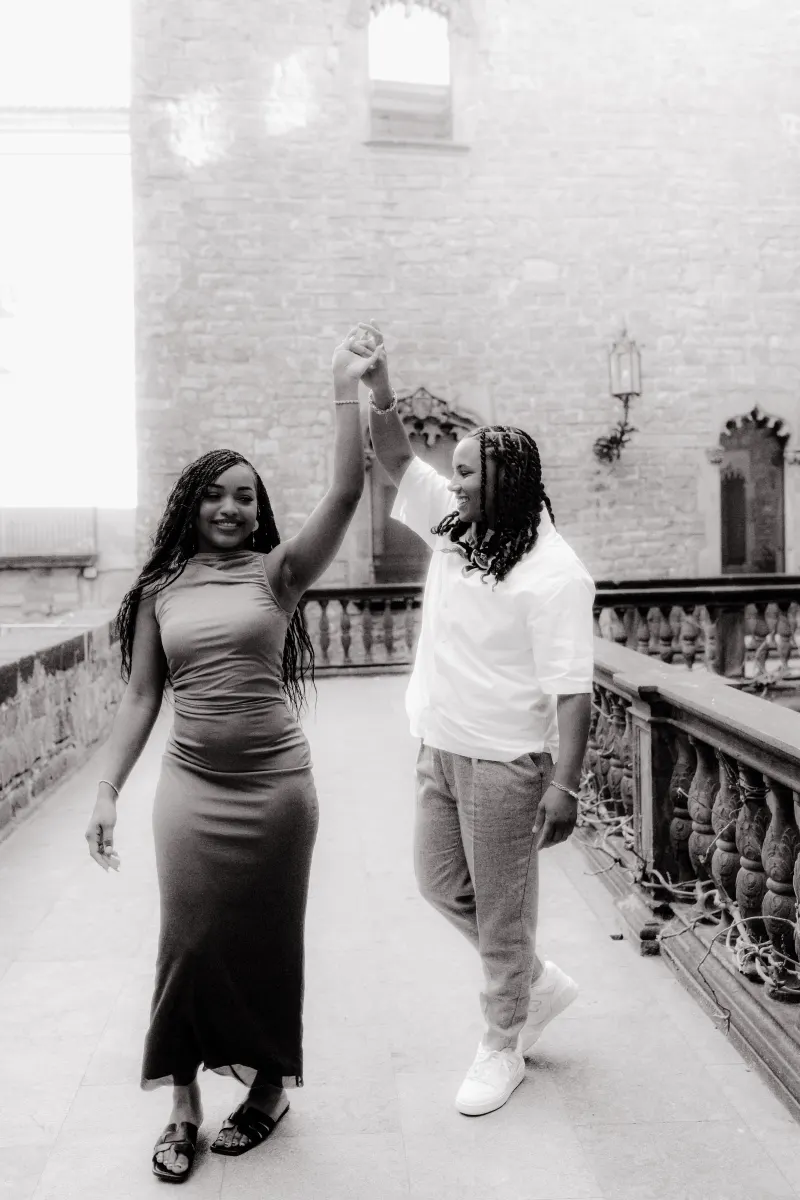 Couple dances and smiles together on a historic Barcelona terrace during their surprise proposal photoshoot.